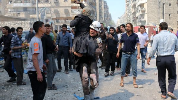 A Syrian civil defense volunteer evacuates a woman following a reported airstrike on April 23, 2016 in Aleppo. (AFP/Ameer Alhalbi)