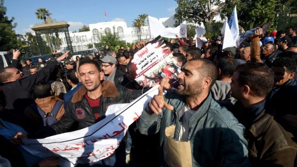 Tunisian unemployed people shout slogans during a demonstration against the government's policy on December 10, 2016 outside the Assembly of the Representatives of the People in Tunis, as the draft budget for 2017 is being reviewed by parliament. (AFP/Fethi Belaid)