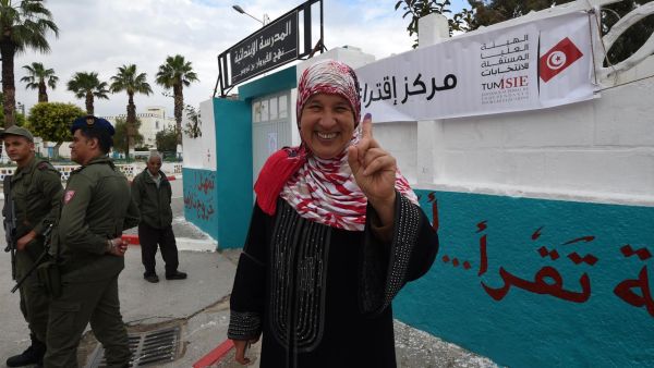 A Tunisian woman voter showcases her ink-stained index finger outside a polling station in Ben Arous near the capital Tunis on May 6, 2018. (AFP/File Photo)