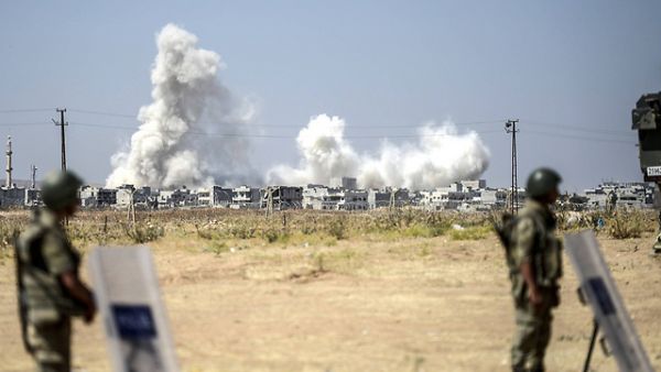 Turkish border guards watch as smoke rises from an airstrike in Syria. (AFP/File)