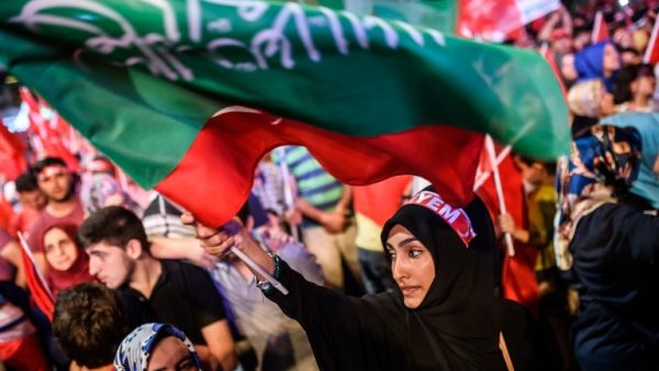 A woman waves flags during a pro-Erdogan rally in Taksim square in Istanbul on July 22, 2016, following the failed military coup attempt of July 15. (AFP/Ozan Kose)