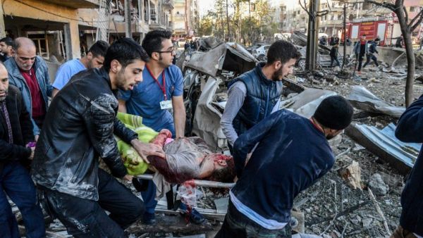 Rescue officials and people carry an injured man at the explosion site on November 4, 2016 after a strong blast in the southeastern Turkish city of Diyarbakir. (AFP/Ilyas Akengin)