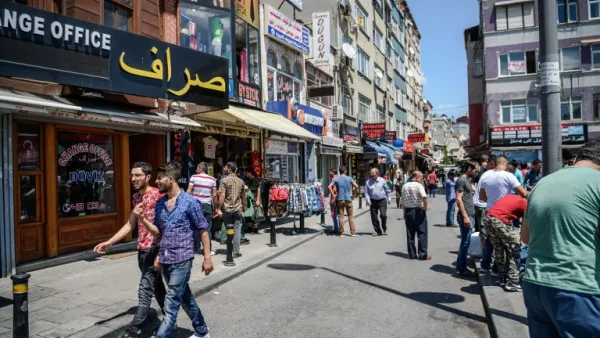 Syrian and Turkish people walk in a street next to shops with Arabic signs on July 4 ,2016 in Fatih neighborhood in Istanbul. (AFP/Ozan Kose)