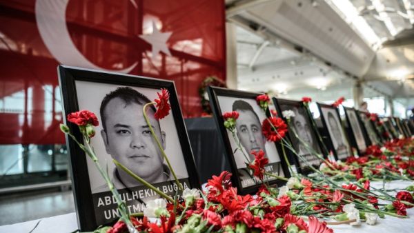 Flowers left by airport employees next to photos of victims killed during the triple suicide bombing and gun attack at Istanbul's Ataturk airport. (AFP/Ozan Kose)