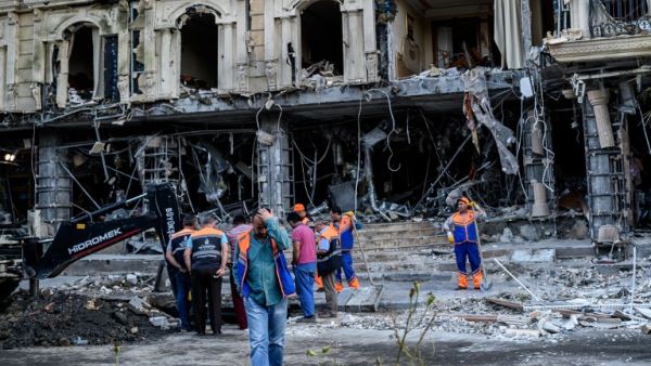 Municipal workers clean the damages caused to a hotel and the road by a bomb in the Vezneciler district of Istanbul on June 7, 2016. (AFP/Ozan Kose)