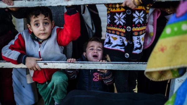 Syrian families at a Turkish border gate near Kilis on February 8, 2016. (AFP/Bulent Kilic)