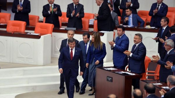 People applaud as Turkey's outgoing Prime Minister Ahmet Davutoglu (C) walks on May 17, 2016 during the discussions on the ruling AK Party's proposal regarding the amendment of the immunity at the Turkish Parliament in Ankara. (AFP/Adem Altan)