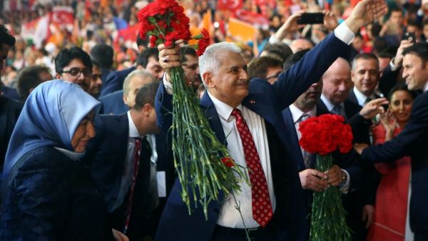 Turkey's Minister of Transport, Maritime and Communication and new chairman candidate for ruling AK Party Binali Yildirim greets supporters as he arrives with his wife Semiha Yildirim for the second extraordinary congress of the AK Party in Ankara, on May 22, 2016. (AFP/Adem Altan)
