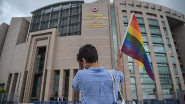 A person waves a rainbow flag in front of Istanbul courthouse on June 19, 2017 in support to eleven LBTG activists who went on trial. Eleven LBTG activists appeared on trial on June 19 in Istanbul for having marched during last year's Gay Pride, which was banned. All charges against them have been dropped, and activists called for a demonstration on June 25. (Ozan Kose/AFP)