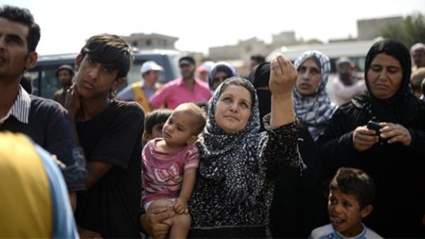 A Syrian refugee woman gestures as she waits for supply near the Turkish border post of Akcakale in the province of Sanliurfa, June 17, 2015. (AFP)