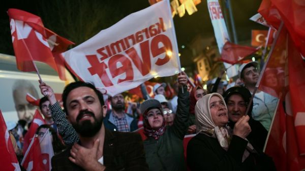 Supporters of Turkish President Erdogan wave Turkish national flags and flags reading "yes" as they celebrate during a rally on April 16, 2017 in Istanbul after the results of a nationwide referendum. (AFP/Ozan Kose)