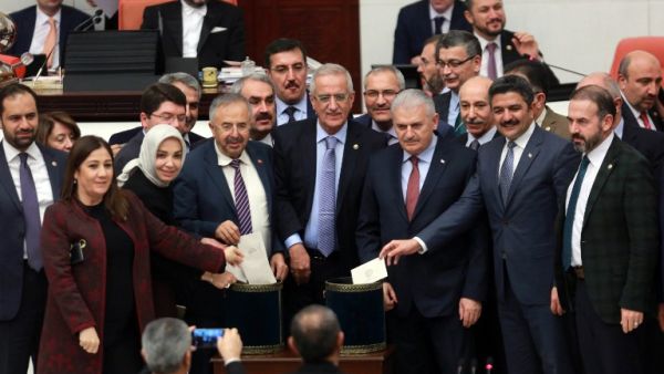 Turkish Prime Minister Binali Yildirim (3rd R) and lawmakers pose as they cast their ballots during a vote on provisions in a bill to change the constitution at the Turkish parliament in Ankara on January 14, 2017. (AFP/Adem Altan)