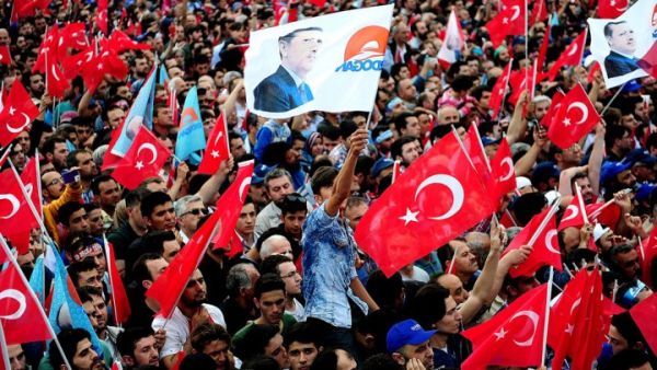People wave Turkish flags, and one bearing the image of President Recep Tayyip Erdogan. (AFP/ File)