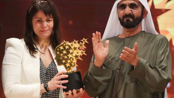 Canadian teacher Maggie MacDonnell (L) receives the Global Teacher Prize from Sheikh Mohammed bin Rashid al-Maktoum, vice-president and Prime Minister of the UAE and Ruler of Dubai, during a ceremony in Dubai on March 19, 2017. (AFP/Karim Sahib)