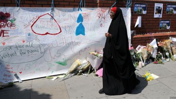 A woman walks past messages attached to a wall near the scene of an attack next to Finsbury Park Mosque, in north London, June 20, 2017. (AFP/ File)