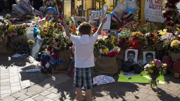 A boy raises his arms in the air in front of a memorial at the Muhammad Ali Center on June 10, 2016 in Louisville, Kentucky.  (AFP/Ty Wright)