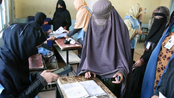 An Afghan Independent Election Commission (IEC) official scans a voter with a biometric device at a polling centre for the country's legislative election in Kandahar province on October 27,2018. (JAWED TANVEER / AFP)