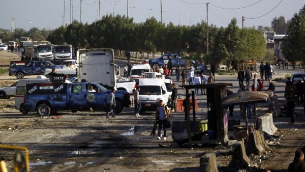 Iraqi emergency responders inspect debris at the site of a truck bomb that exploded at a crowded checkpoint in the Iraqi city of Hilla, south of Baghdad. (AFP/ File)