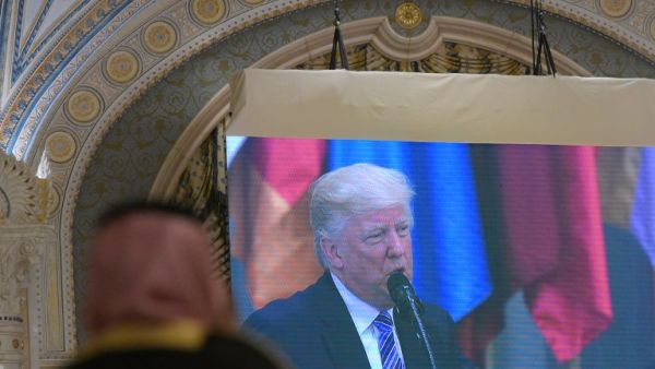 A man watches an image of US President Donald Trump as he speaks during the Arabic Islamic American Summit at the King Abdulaziz Conference Center in Riyadh on May 21, 2017.  (MANDEL NGAN/AFP)