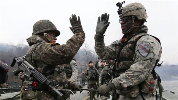 Soldiers from South Korea (L) and the US (R) gesture as they set up a floating bridge during a US-South Korea joint river crossing exercise. (AFP/ File Photo)