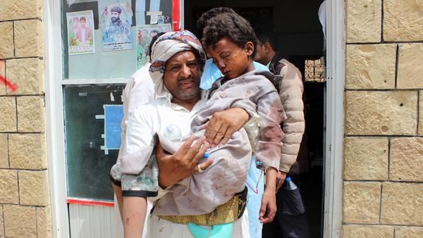A man carries a wounded child to the hospital Thursday after the Saudi-led coalition carried out an airstrike on a crowded area in Houthi-controlled Saada province. (AFP/File)