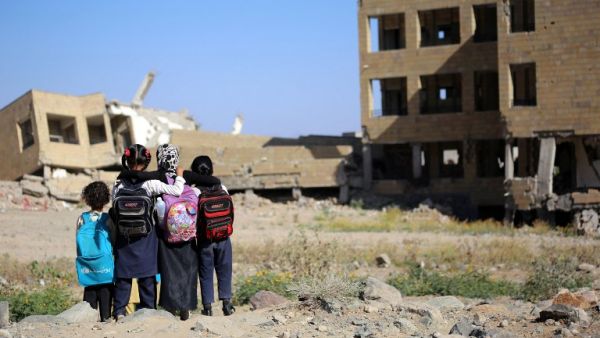 Yemeni school girls look at a school on March 16, 2017, that was damaged in an air strike in the southern Yemeni city of Taez. (AFP/Ahmad al-Basha)