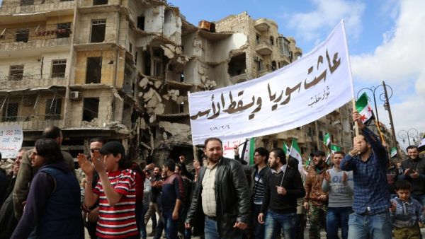 Syrian civilians and activists wave pre-Baath Syrian flags, now used by the Syrian opposition, during an anti-regime demonstration in the rebel-controlled side of Aleppo, on March 4, 2016. (AFP/Karam al-Masri)