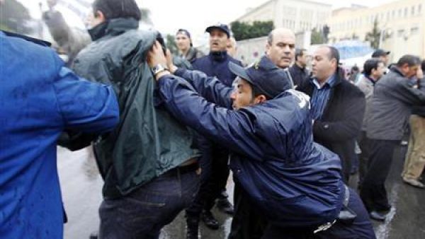 شرطي جزائري يدفع محتجا أثناء مظاهرة في العاصمة الجزائرية 
