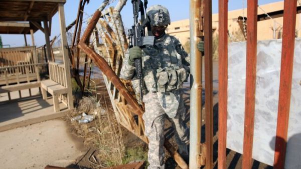 An American soldier walks through a fence at the Taji military base in northern Baghdad in 2014. (AFP/File)