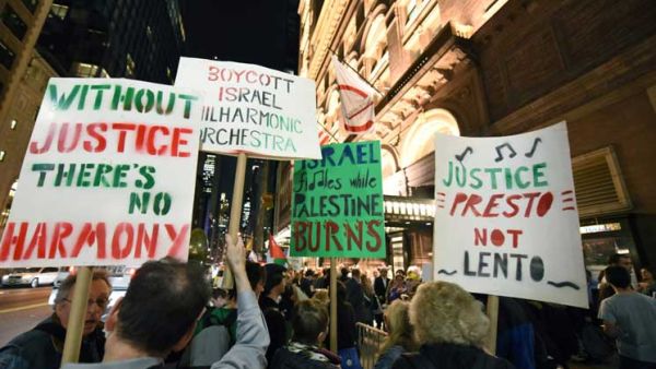 حمل المحتجون لافتات كتبوا عليها عبارات رافضة لوجود الأوركسترا  
