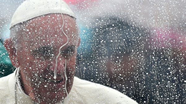  زعيم الفاتيكان فرنسيس خلف زجاج كساه المطر 