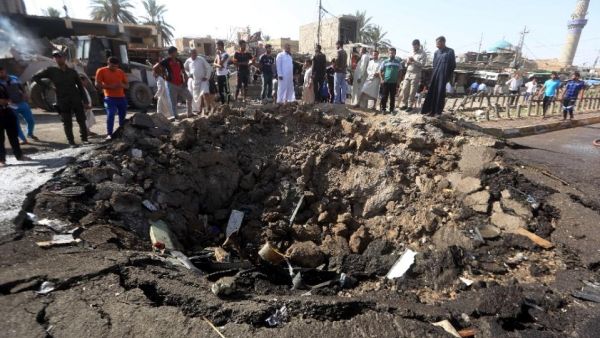 Iraqi men look at a crater on July 18, 2015 left by the car bomb attack the previous day in Khan Bani Saad, 20 km north of Baghdad. (AFP/Ahmad Al-Rubaye)
