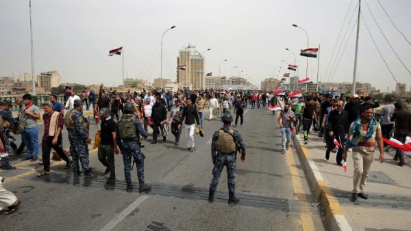 Iraqi security forces stand guard during a protest by supporters of Iraqi Shiite cleric Moqtada al-Sadr calling for reforms on March 25, 2016, outside the main gates of Baghdad's Green Zone. (AFP/Ahmad al-Rubaye)