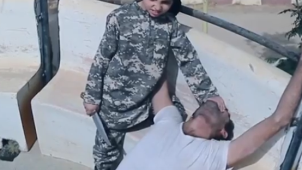 طفل داعشي يذبح رجلا بسكين حاد