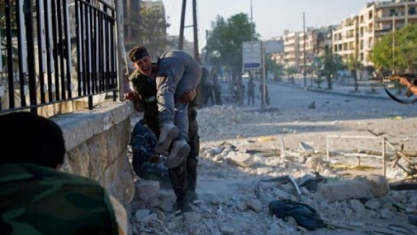 A man carrying a wounded friend after airstrikes in Idlib. (AFP/File)