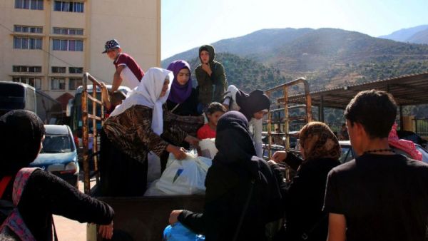 Syrian refugees gather their belongings in the southern Lebanese village of Shebaa as they prepare to return to Syria on August 13, 2018 (AFP/Ali DIA)