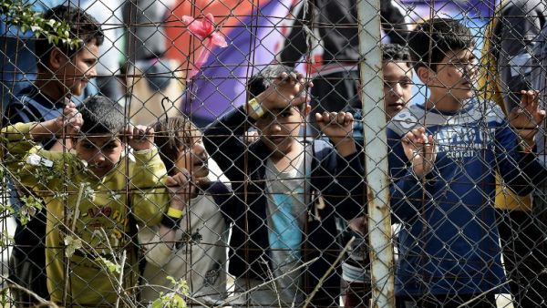 Children look through the fence at the Moira detention facility. (AFP/File)