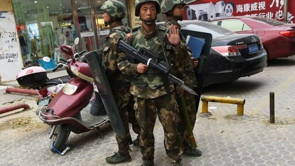 Paramilitary police stand guard outside a mall in Hotan, in China's western Xinjiang region. (AFP/File) 