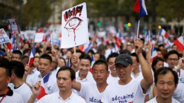 مشاركون في احتجاج للجالية الصينية في باريس يوم الأحد
