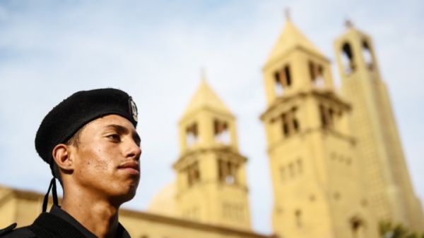An Egyptian policeman stands guard in front of a church (AFP/File Photo)