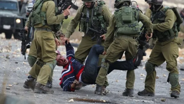 Israeli soldiers detain a Palestinian stone thrower near Beit El, on the outskirts of the West Bank city of Ramallah, on October 7, 2015. (AFP/Abbas Momani)