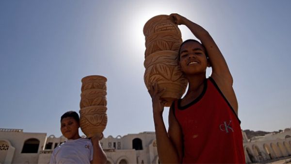 Egyptian boys carry clay pots at a workshop in the old city of the capital Cairo. (AFP/File)