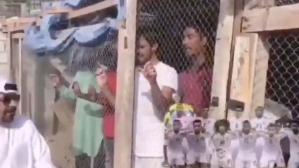 The Emirati man is seated outside a bird cage containing migrant workers inside [Twitter]