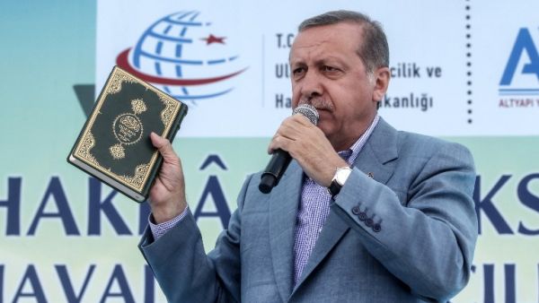Turkey's President Recep Tayyip Erdogan holds a Koran as he speaks during an opening ceremony at the Selehaddin Eyyubi airport on May 26, 2015, in eastern city of Hakkari. (AFP/STR)