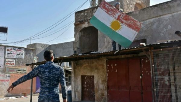 An Iraqi fighter loyal to Baghdad removes a Kurdish flag from a building in the Altun Kupri region of Kirkuk province on October 20, 2017. (AFP/File)