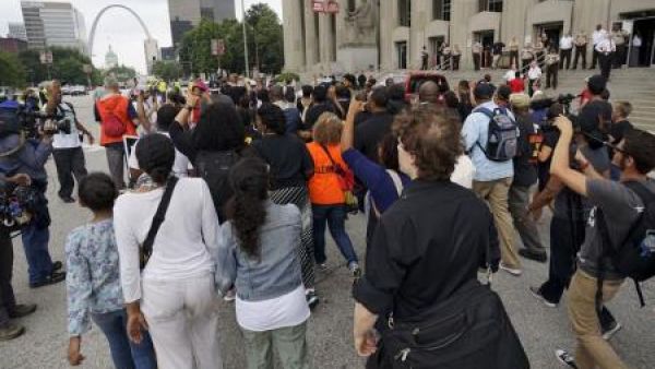 محتجون يسيرون في مقاطعة سانت لويس يوم الاثنين بمناسبة ذكرى مرور عام على مقتل شاب أسود.
