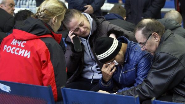 Relatives of the victims of the airplane crash speak with a Russian Emergency psychologist (L) at the airport in Rostov-on-Don on March 19, 2016. at the airport in Rostov-on-Don on March 19, 2016. (AFP/Sergei Venyavsky)