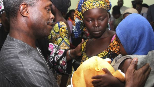 One of the 21 freed Chibok girls cries while holding her baby as Nigerian Vice President Yemi Osinbajo looks on at his office in Abuja on October 13, 2016. (AFP/Philip Ojisua)