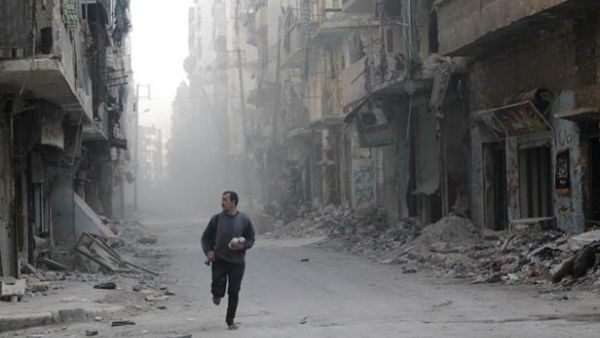 A Syrian rebel runs through a street in Aleppo during clashes with government troops. (AFP/File)