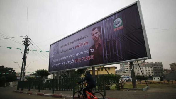  لافتة ضخمة في غزة تحمل صورة جندي إسرائيلي أسير لديها